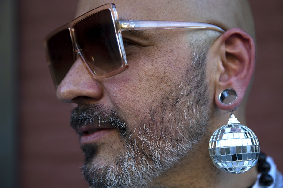 caption: Dominic Ruiz wears disco ball earrings before attending Beyonce’s Seattle stop on the Renaissance World Tour on Thursday, Sept. 14, 2023, near Lumen Field in Seattle.