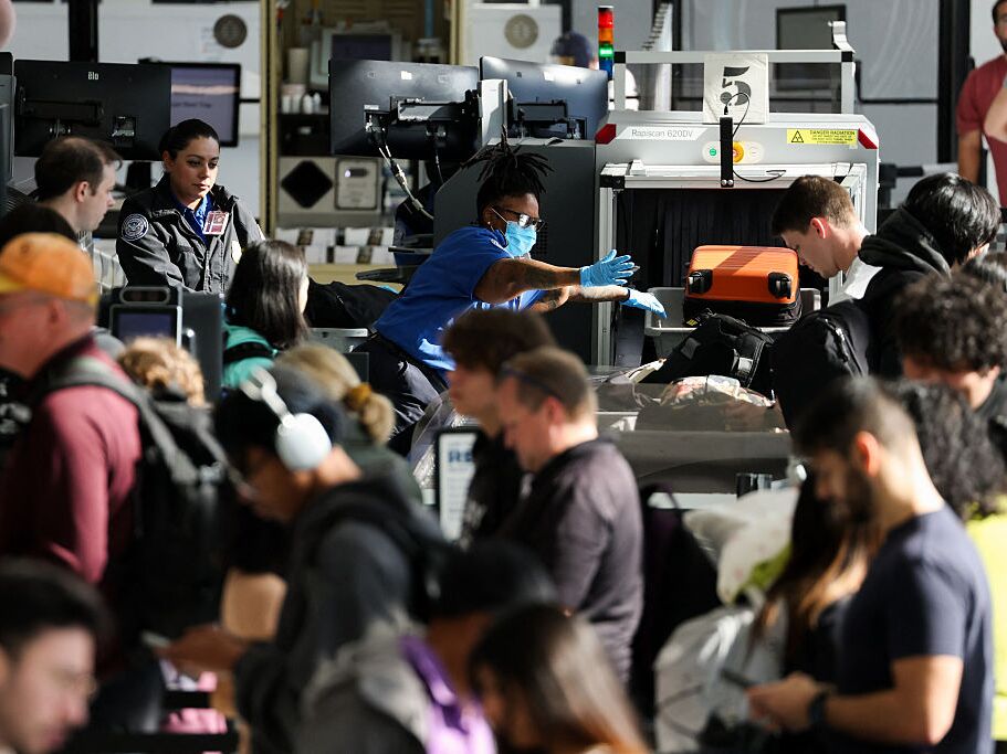 caption: Passengers wait in line at a Transportation Security Administration checkpoint while traveling at Los Angeles International Airport in November 2025.