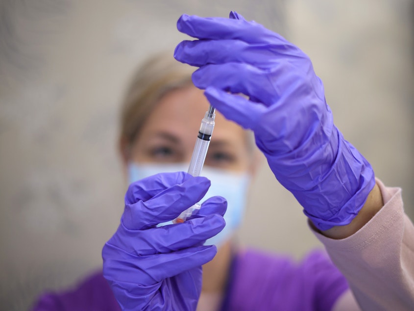 caption: A nurse draws a vaccine dose from a vial of Moderna's COVID vaccine at the Cameron Grove Community Center in Bowie, Md., in March.