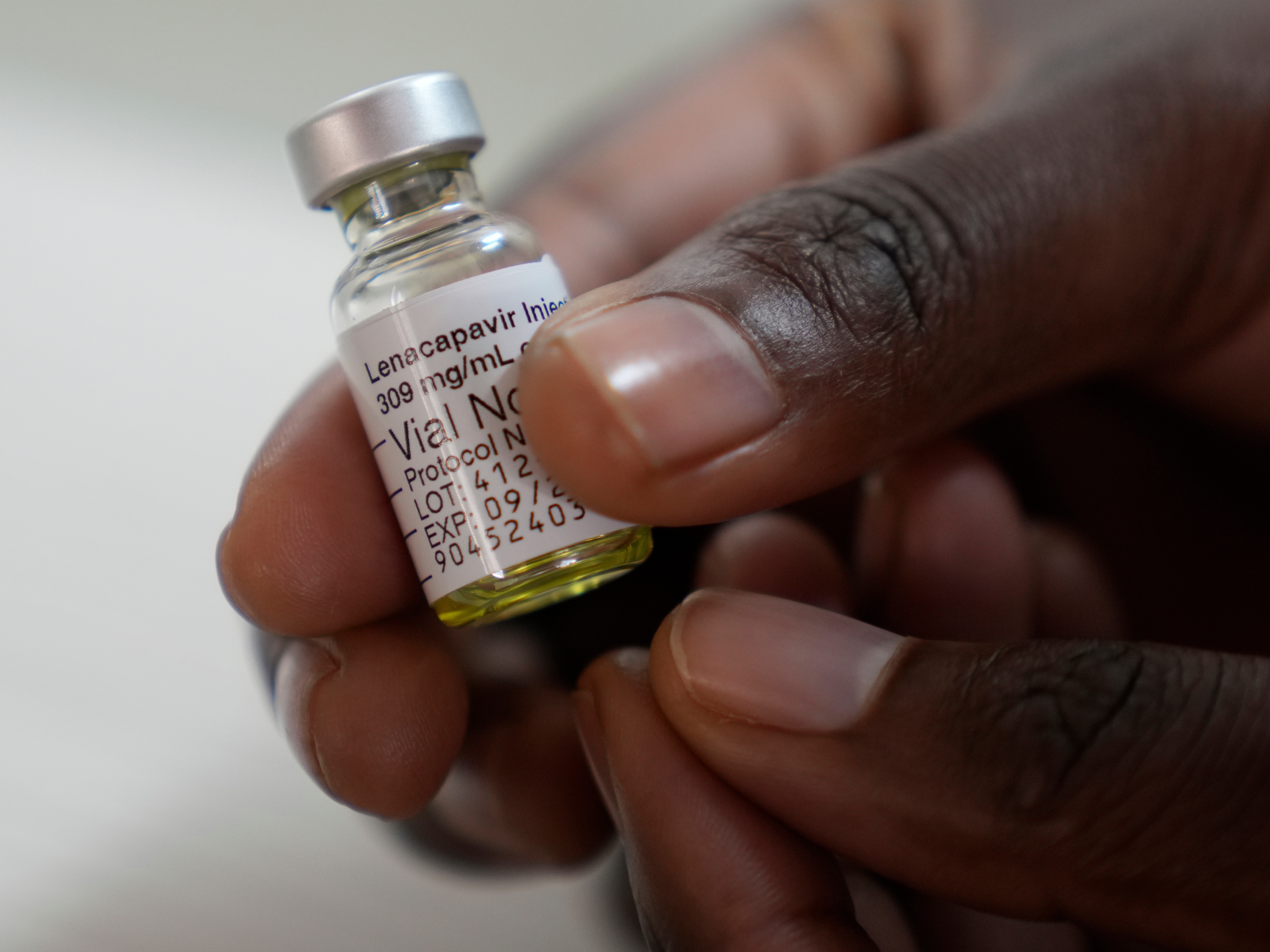 caption: A pharmacist holds a vial of lenacapavir, described as a "breakthrough" HIV prevention drug, at a research site in South Africa.