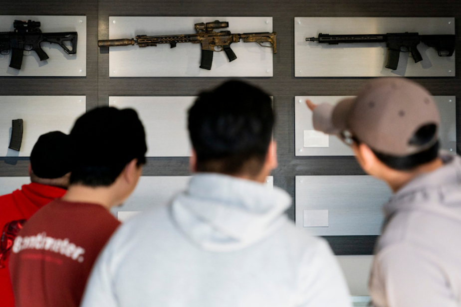 caption: Customers look at AR-15-style rifles on a mostly empty display wall at Rainier Arms Friday, April 14, 2023, in Auburn, Wash. as stock dwindles before potential legislation that would ban future sale of the weapons in the state. House Bill 1240 would ban the future sale, manufacture and import of assault-style semi-automatic weapons to Washington State and would go into immediate effect after being signed by Gov. Jay Inslee. 
