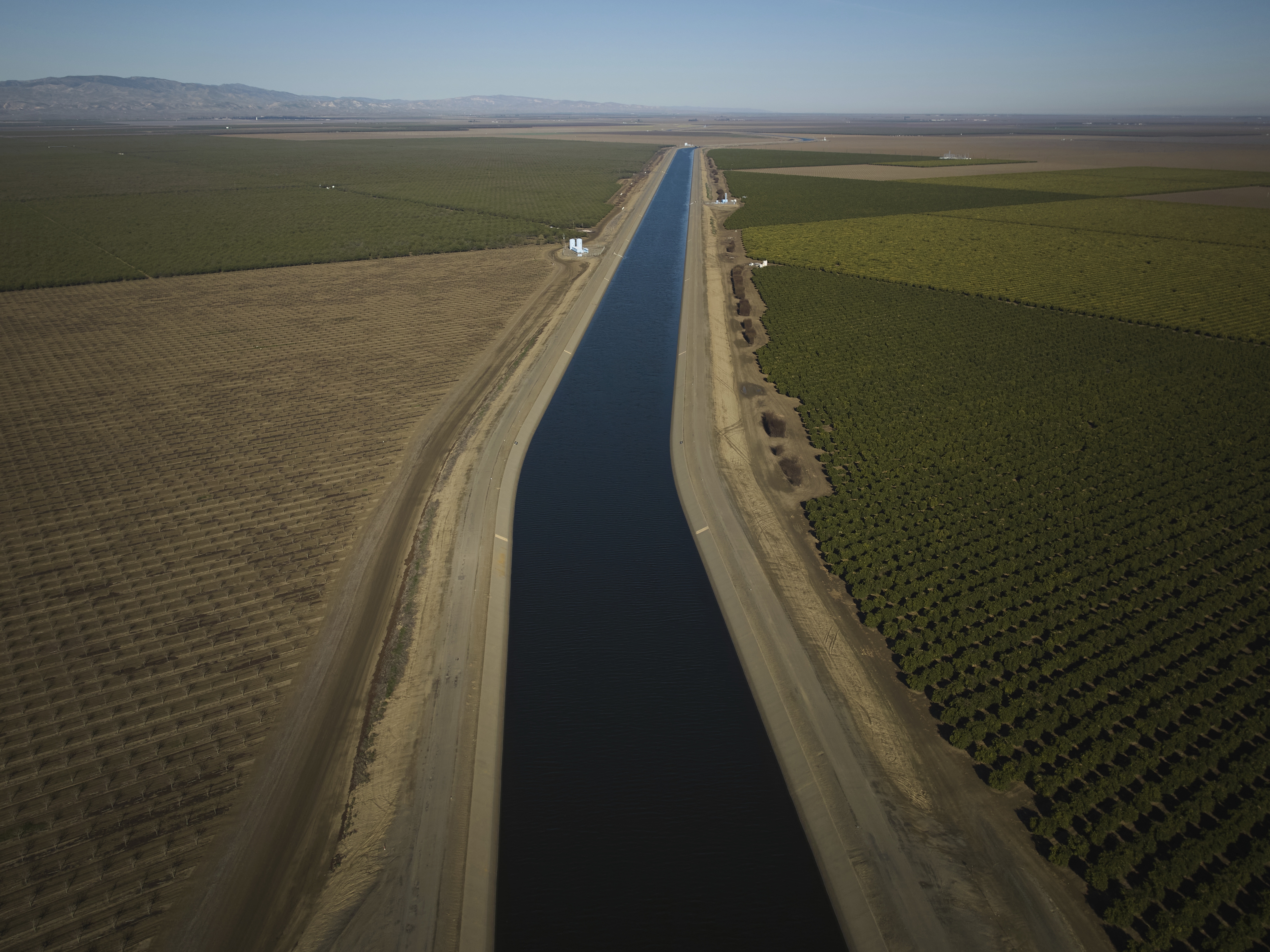 caption: The San Luis Canal flows alongside farmland in Huron, Calif. Some farmers in the region are leaving land fallow because water is increasingly scarce.