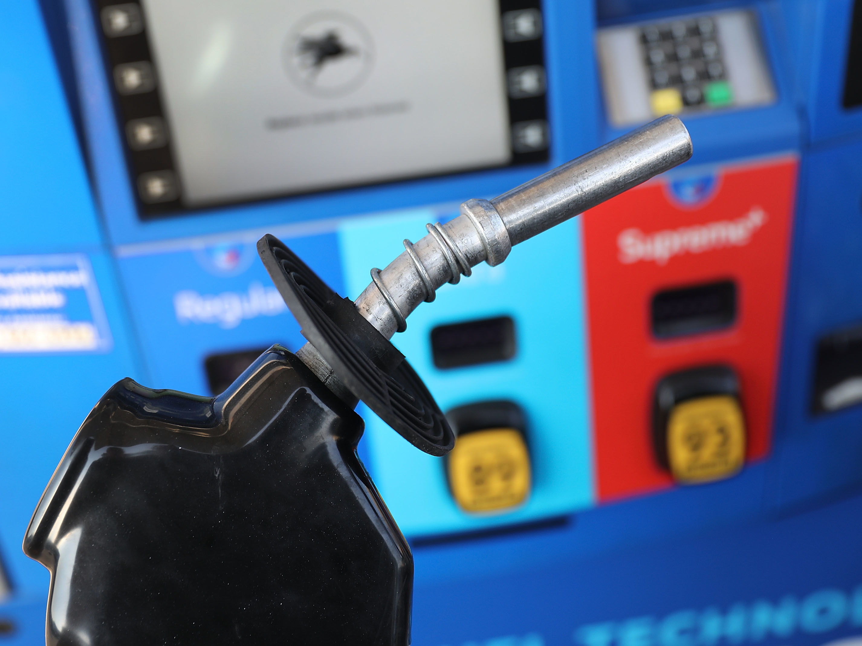 caption: A gas pump nozzle is seen at a Miami gas station in 2018. Some activist shareholders are pushing companies to tie executive compensation to meeting climate targets.