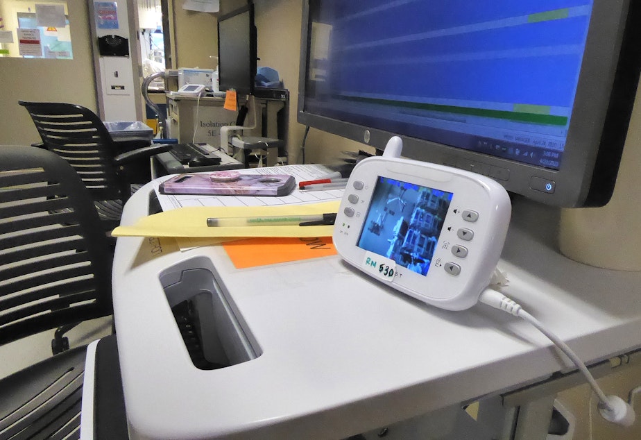 caption: Nurses on the Covid ICU at the UW Medical Center in Seattle monitor their patients by using baby monitors and Zoom, the video chat app. This allows them to limit visits into the room, and therefore protect themselves and others working on the ward.