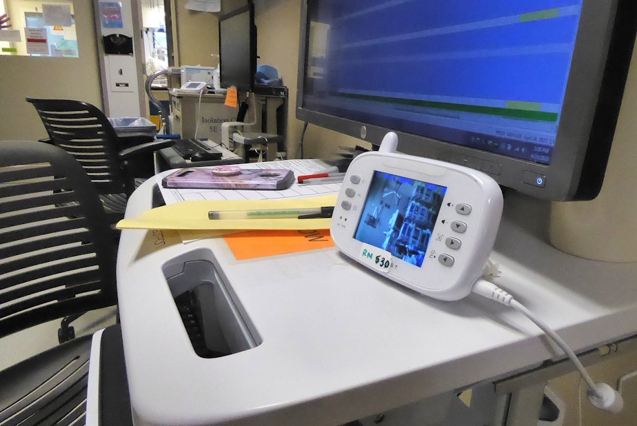caption: Nurses on the Covid ICU at the UW Medical Center in Seattle monitor their patients by using baby monitors and Zoom, the video chat app. This allows them to limit visits into the room, and therefore protect themselves and others working on the ward.