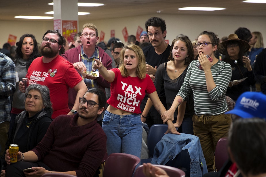 caption: Supporters including Keely Mulen, center, and Tiffani McCoy, right, react as early election results show Kshama Sawant trailing behind District 3 opponent Egan Orion on Tuesday, November 5, 2019, during an election night party at Langston Hughes Performing Arts Institute in Seattle. 