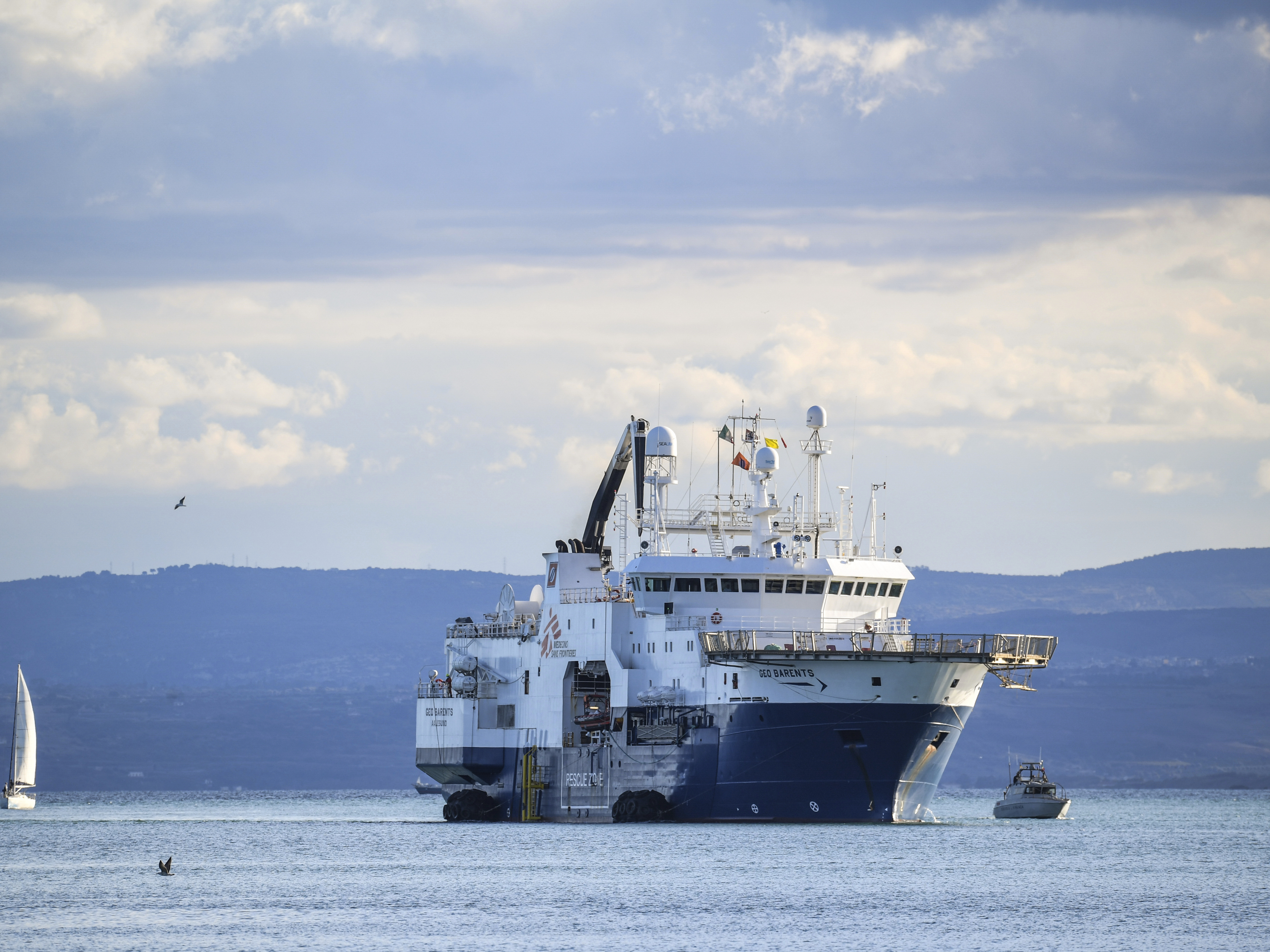 caption: The Norway-flagged Geo Barents rescue ship carrying nearly 600 migrants arrives at Catania's port in Sicily on Sunday.