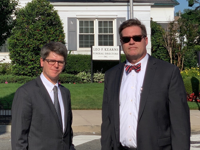 caption: Fourth-generation funeral home director Patrick Kearns (left) and his business partner and brother-in-law Paul Kearns-Stanley stand in front of their funeral home in North Richmond Hill, Queens.