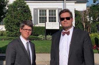 caption: Fourth-generation funeral home director Patrick Kearns (left) and his business partner and brother-in-law Paul Kearns-Stanley stand in front of their funeral home in North Richmond Hill, Queens.