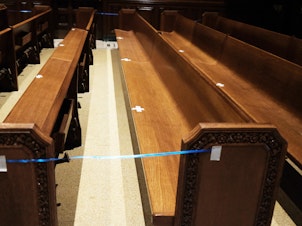 caption: Empty pews are marked for spacing in a Manhattan church on Nov. 27, 2020 in New York City.