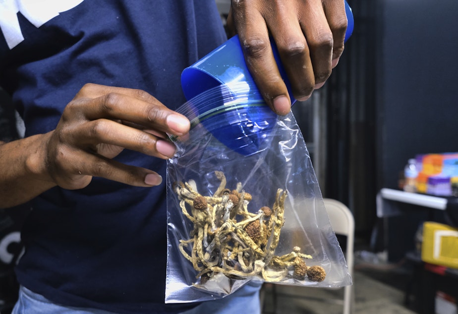 caption: In this Friday, May 24, 2019 photo a vendor bags psilocybin mushrooms at a pop-up cannabis market in Los Angeles.