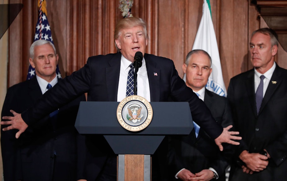 caption: President Donald Trump, accompanied by from left, Vice President Mike Pence, Environmental Protection Agency Administrator Scott Pruitt, and Interior Secretary Ryan Zinke, speaks at EPA headquarters in Washington, March 28.