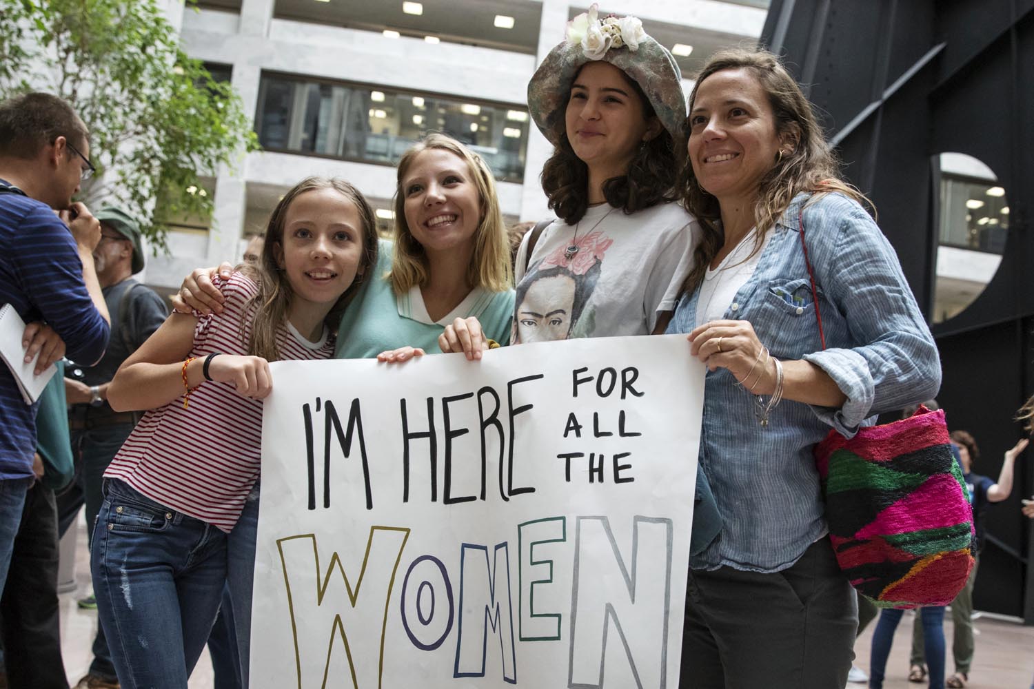 caption: Jessica Lusty of Washington, right, holds a sign with young activists opposed to President Donald Trump's Supreme Court nominee, Brett Kavanaugh, demonstrate in the Hart Senate Office Building on Capitol Hill in Washington, Thursday, Sept. 20, 2018. (AP Photo/J. Scott Applewhite)