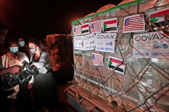 caption: COVID-19 vaccines from COVAX, the international vaccine-sharing program, arrive in Khartoum, Sudan, on Aug. 5. In a letter to President Biden, health experts are asking him to take action to manufacture and distribute vaccines to the entire world.