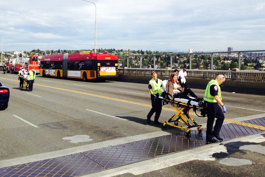 caption: An injured person is taken from the scene of the Aurora Bridge bus crash on Sept. 24, 2015