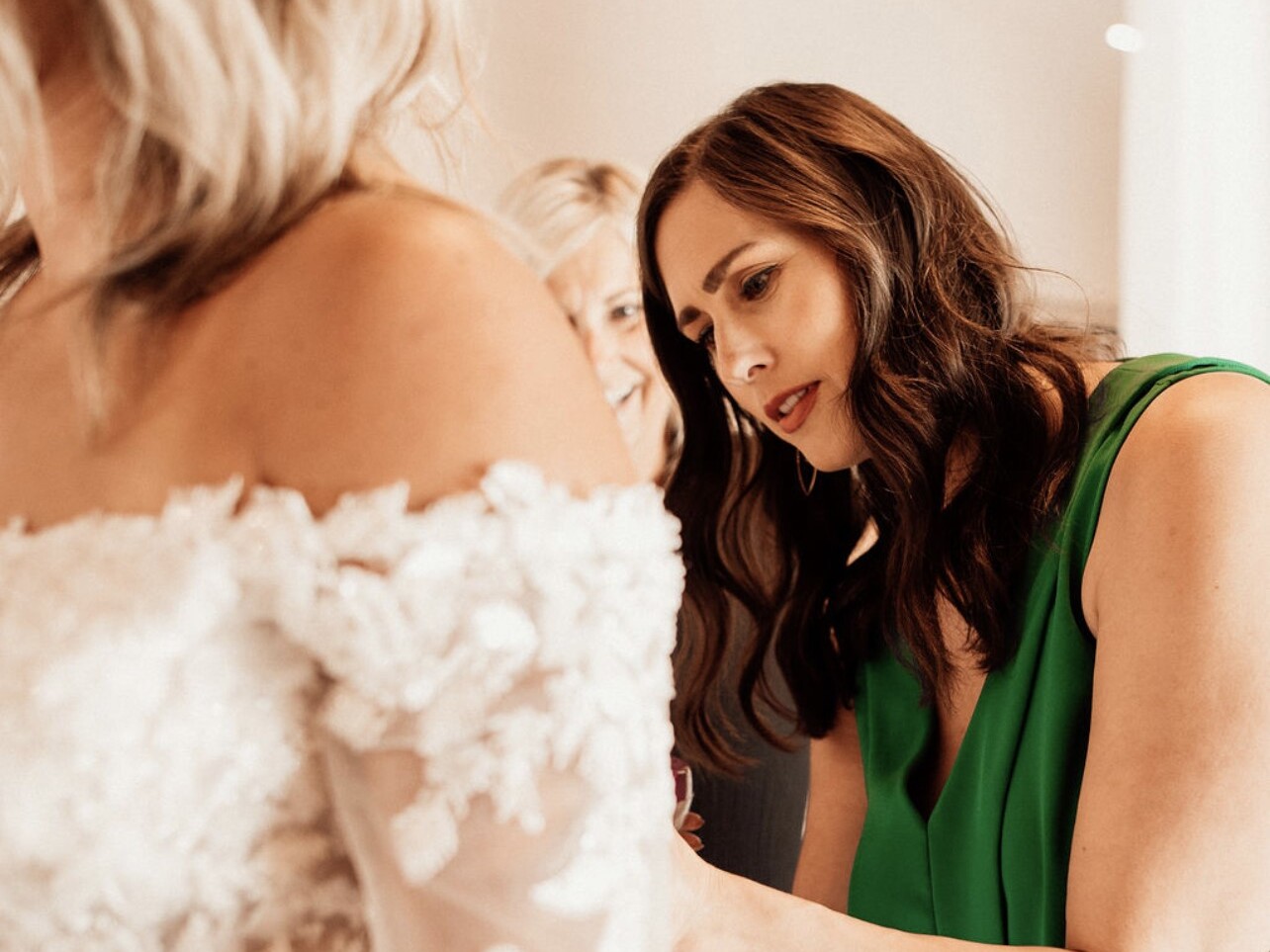 caption: Claire Landgraf helps a bride try on a dress at her shop Finery Bridal Chic in Rochester, Minn.