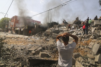caption: Palestinians look for survivors of the Israeli bombardment of the Gaza Strip in Rafah on Monday.