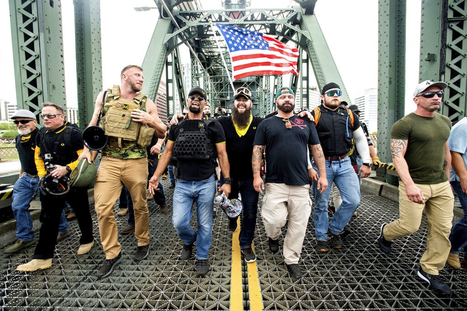 caption: Members of the Proud Boys, including chairman Enrique Tarrio, and organizer Joe Biggs, third from right, march across the Hawthorne Bridge during an "End Domestic Terrorism" rally in Portland, Ore., on Saturday, Aug. 17, 2019. Biggs was arrested Jan. 20, 2021 for taking part in the siege of the U.S. Capitol on January 6, 2021. 