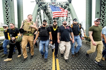 caption: Members of the Proud Boys, including chairman Enrique Tarrio, and organizer Joe Biggs, third from right, march across the Hawthorne Bridge during an "End Domestic Terrorism" rally in Portland, Ore., on Saturday, Aug. 17, 2019. Biggs was arrested Jan. 20, 2021 for taking part in the siege of the U.S. Capitol on January 6, 2021. 