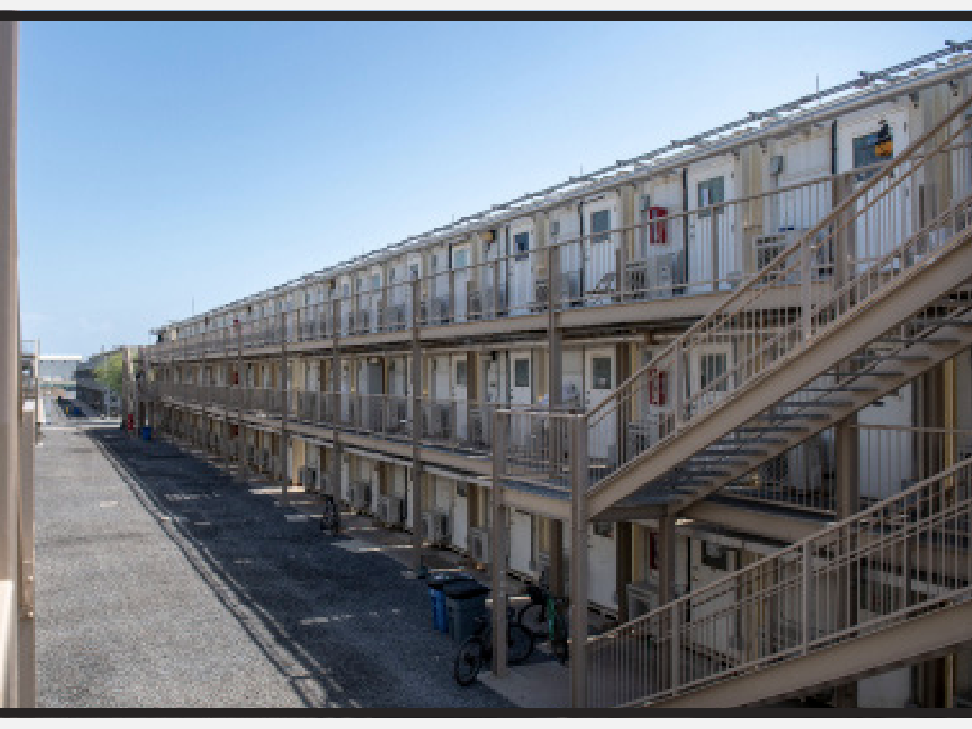 caption: Camp Lemonnier uses stacks and rows of "Containerized Living Units," or CLUs, which the military likens to shipping containers, to house thousands of personnel at the U.S. base in Djibouti. A group of migrants is being held in a converted shipping container, according to court filings.
