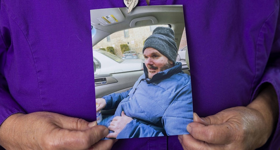 caption: Heidi Aurand holds a photo of her son Adam Aurand who cycled through the streets and jail and was at Washington state's largest psychiatric inpatient facility.