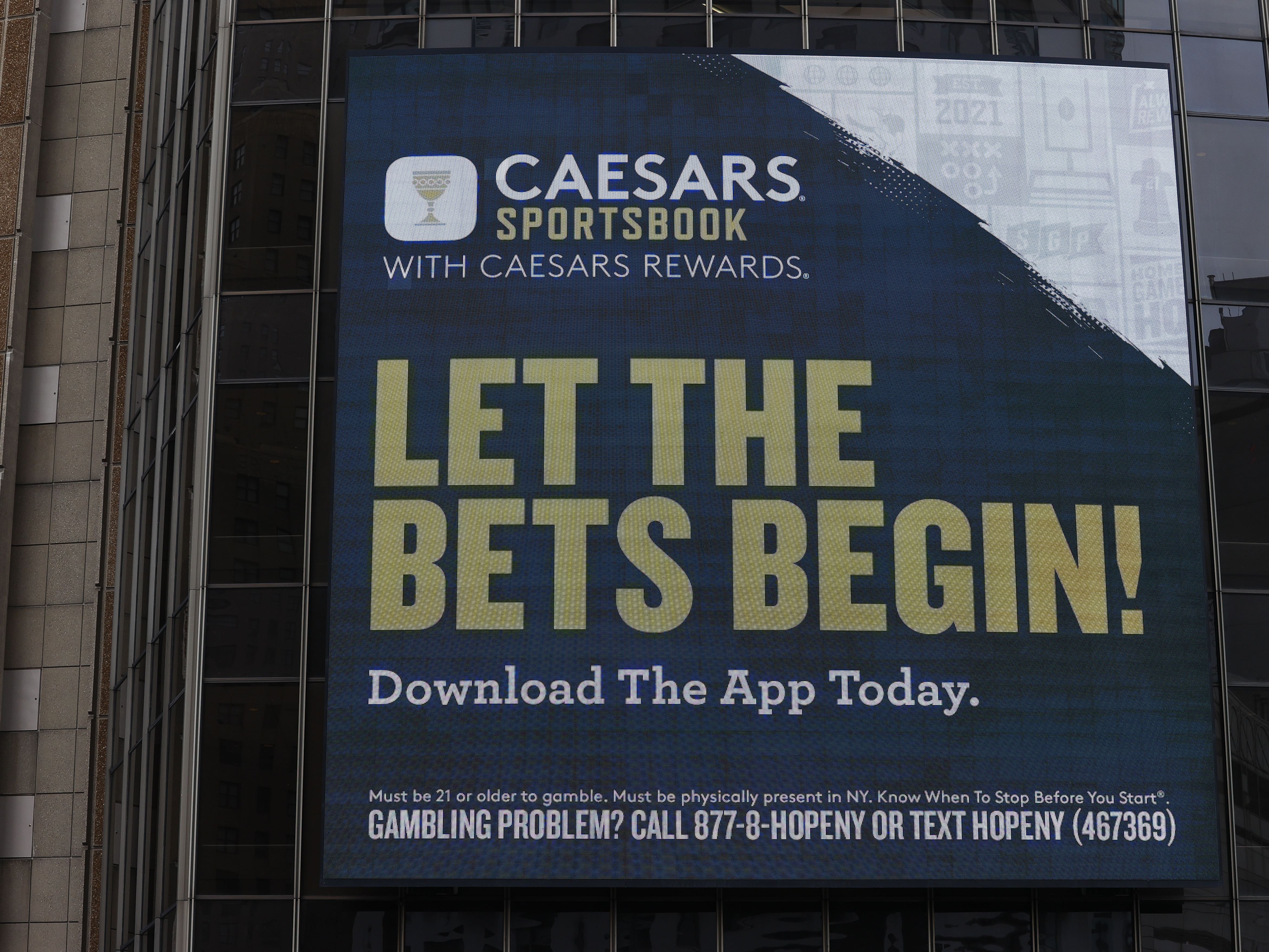 caption: A Caesars Sportsbook gambling advertisement on the exterior of a building in New York City in 2024.