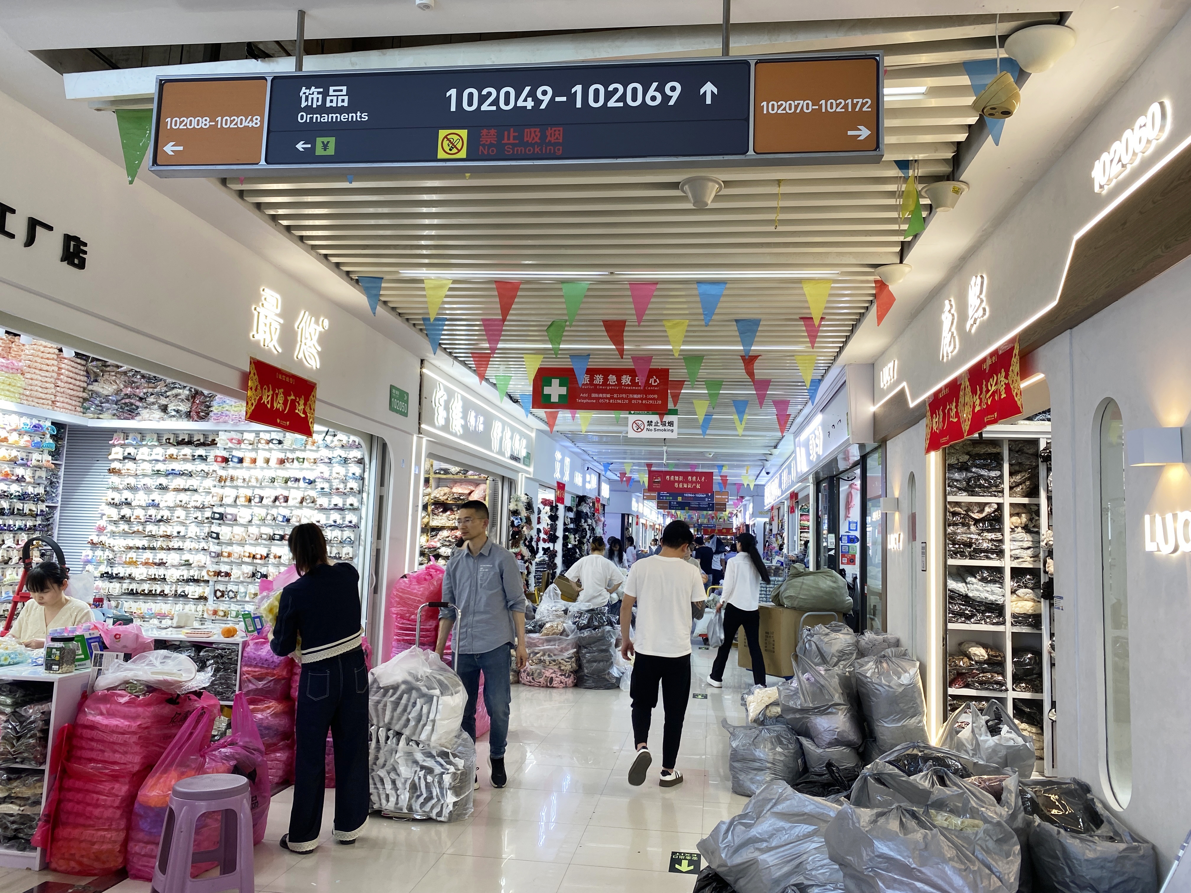 caption: People walk through a building in Yiwu International Trade City, a massive wholesale market in Yiwu, China, where millions of Chinese-made items are sold.