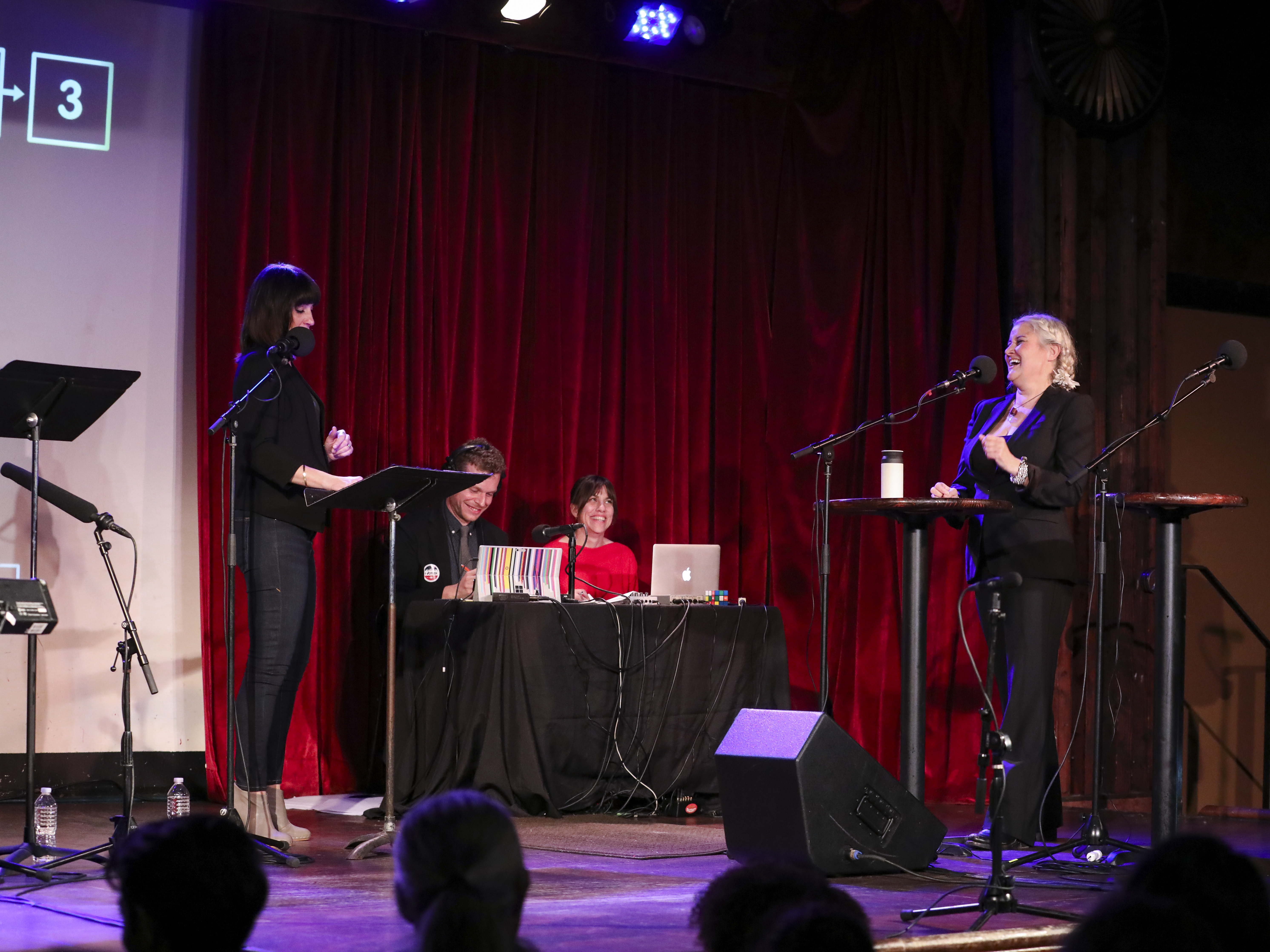 caption: <em>Ask Me Another </em>host Ophira Eisenberg chats with Paula Cole at the Bell House in Brooklyn, New York.