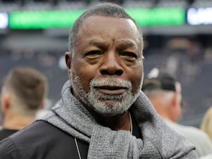 caption: Carl Weathers stands on the sidelines before a Las Vegas Raiders game against the Houston Texans at Allegiant Stadium in Las Vegas in October 2022. He made a posthumous cameo in a 2024 Super Bowl ad.