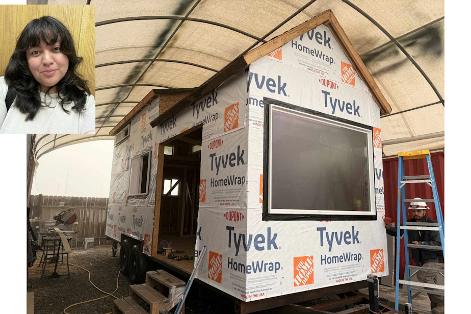caption: Rabecca Rocha and her Tiny House on Wheels under construction at Pacifica Tiny Homes in California. She paid $85,000 for her new home, and had help with a down payment from a relative. She expects to have her loan paid off within 5 years... after which her only cost will be land rent... unless she buys land by then.