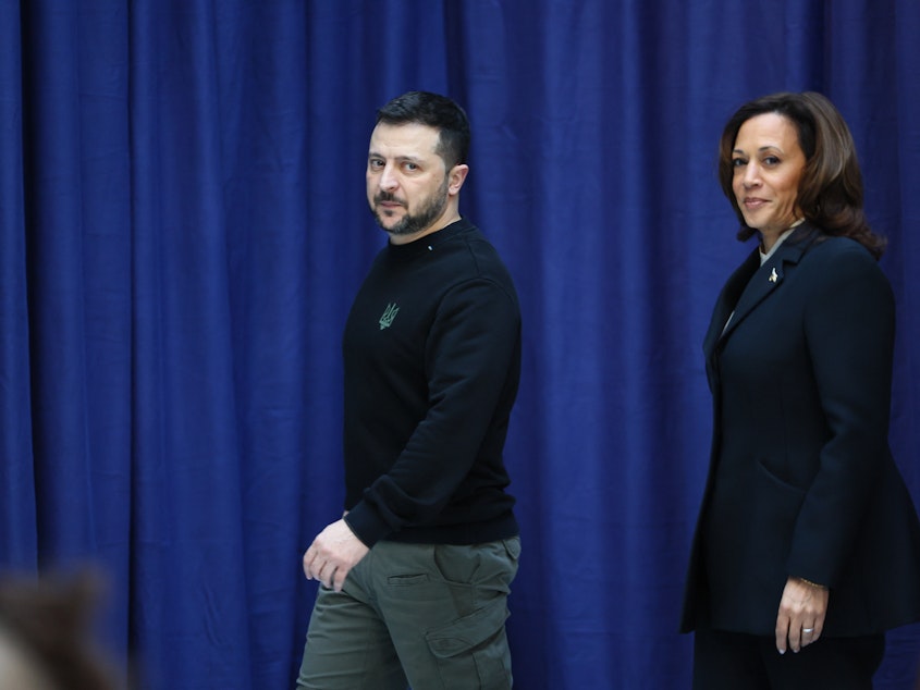 caption: Ukrainian President Volodymyr Zelenskyy and Vice President Harris arrive at a press conference at the Munich Security Conference on Saturday.