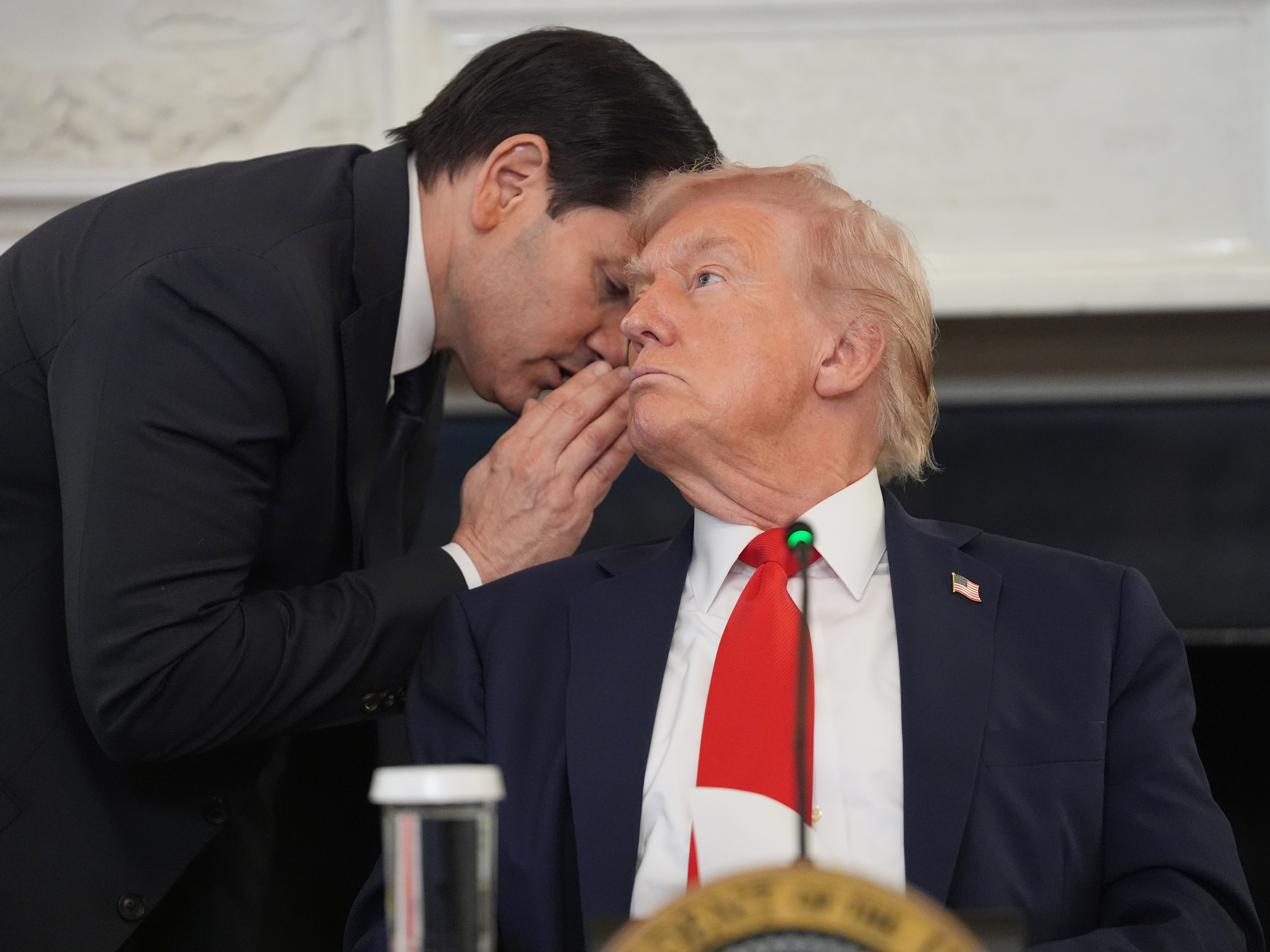 caption: Secretary of State Marco Rubio whispers to President Donald Trump, who is holding the note Rubio handed to him to warn of impending ceasefire deal.