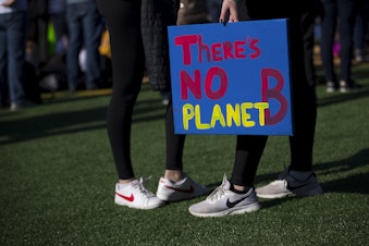 caption: Lucia Kelso, 19, a student at Shoreline Community College, holds a There's No Planet B sign during a student-led strike against climate change on Friday, March 15, 2019, at Cal Anderson Park in Seattle.
