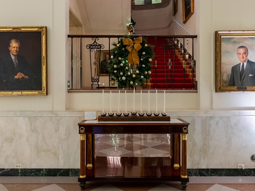 caption: The White House Menorah can be seen in Cross Hall and is part of this year's "We The People"-themed holiday display. The Bidens will add the menorah to the permanent White House collection at a Hanukkah reception Monday evening,