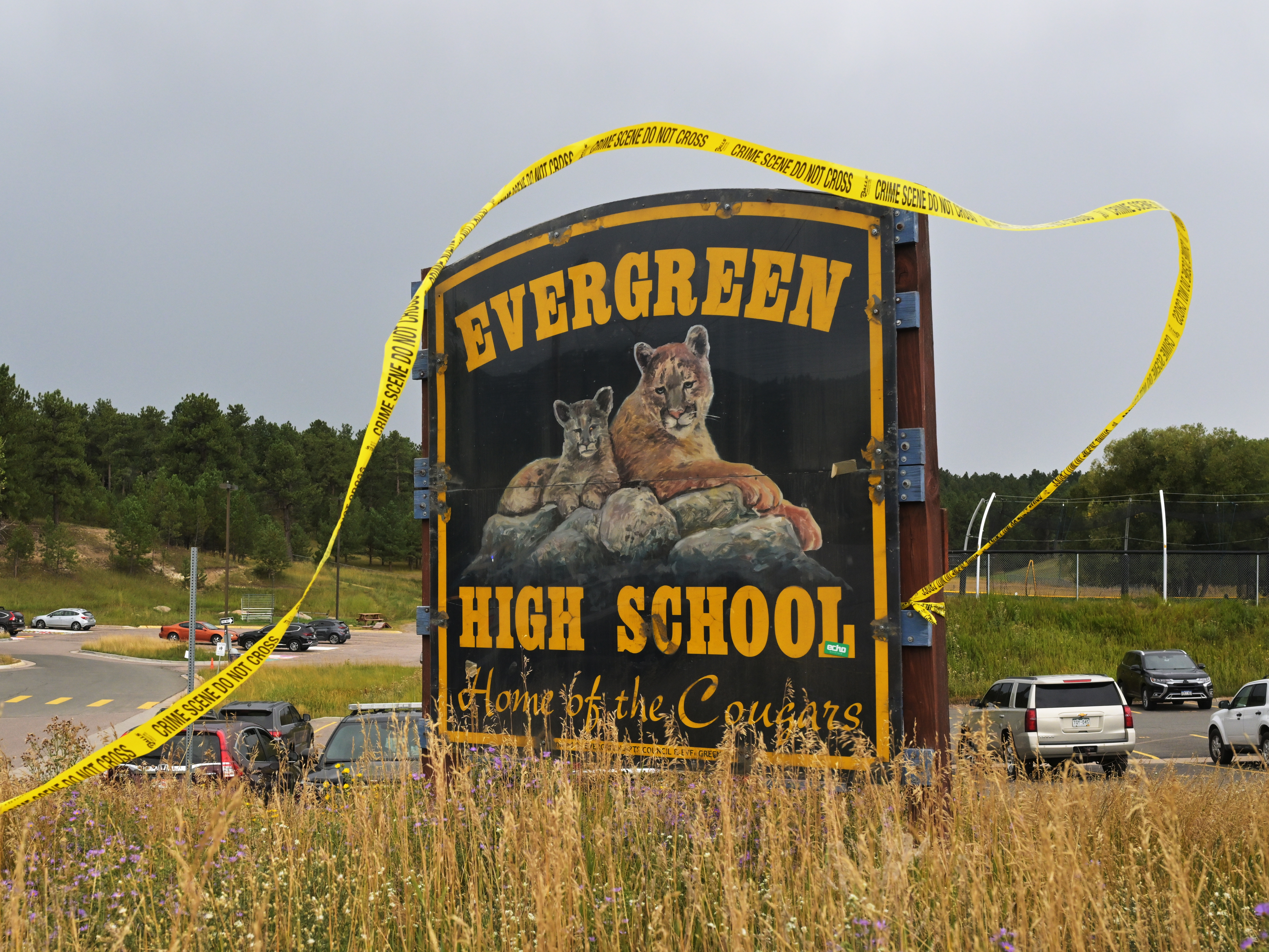 caption: Crime scene tape blows in the wind as rain begins to fall outside Evergreen High School in Colorado on Sept. 11.