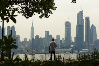 caption: A man takes a look at the haze over the New York skyline during a heat advisory on August 17, 2018, in Weehawken, New Jersey. (Eduardo Munoz Alvarez/Getty Images)