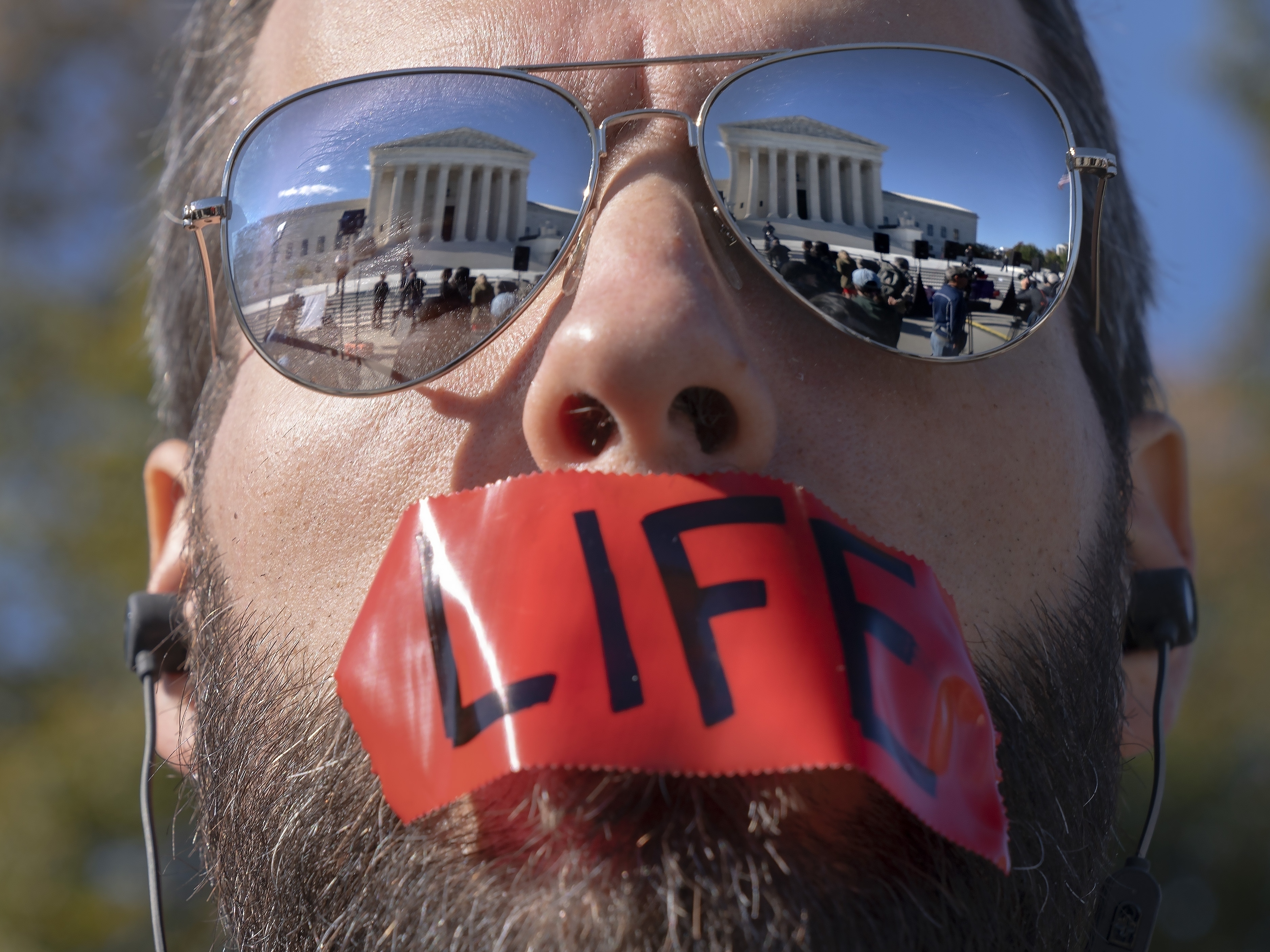caption: An anti-abortion activist rallies outside the Supreme Court on Nov. 1, as arguments about Texas' abortion law begin. The court has allowed the law to remain in place for now.