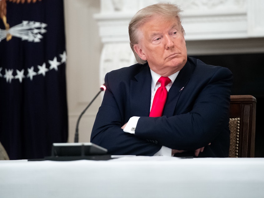 caption: President Trump, seen here during a meeting Thursday at the White House, shared a video on Twitter with a fake CNN headline. The social media network flagged the doctored footage as "manipulated media."