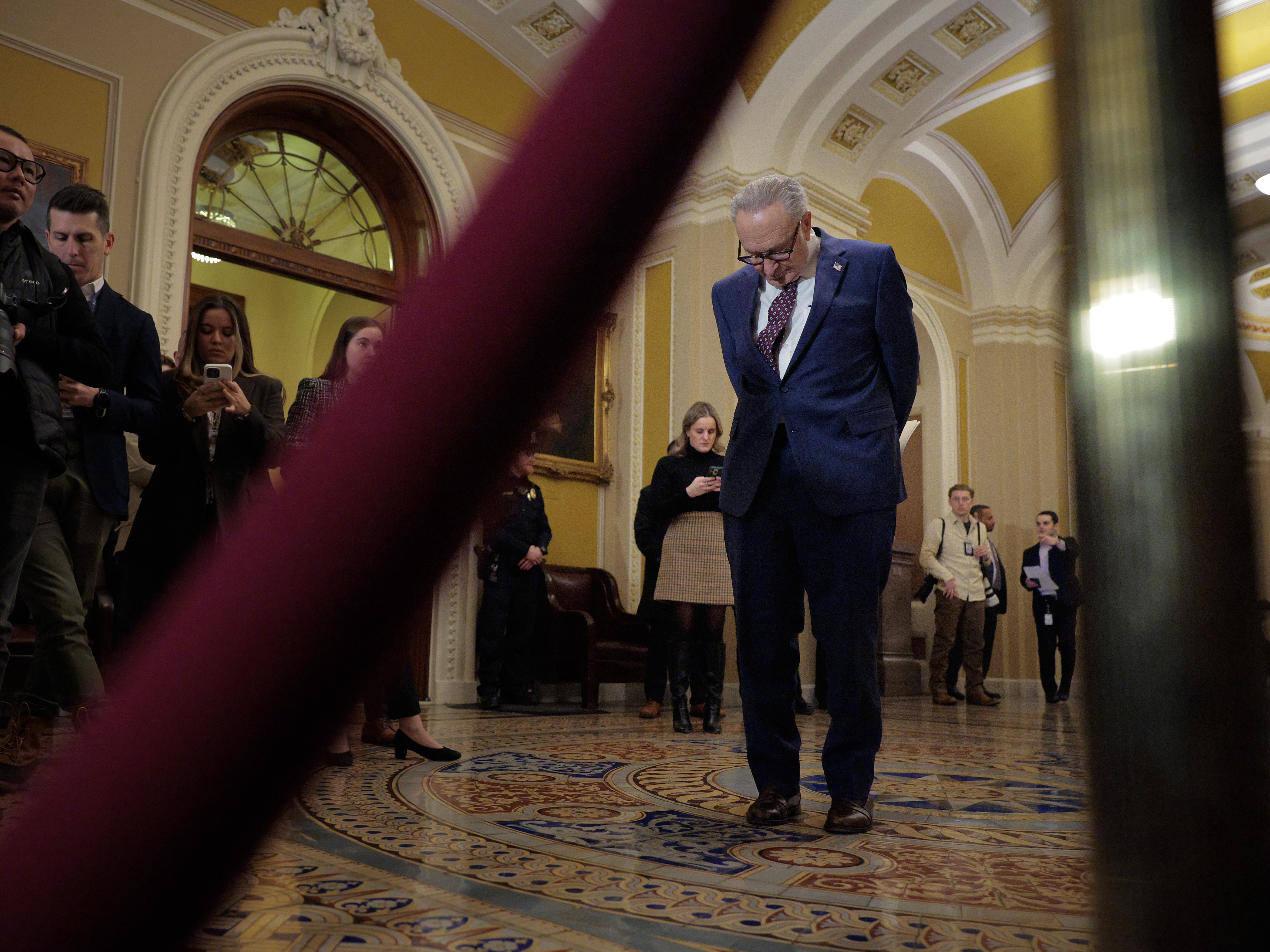 caption: Senate Minority Leader Charles Schumer (D-NY) stands back as fellow Democrats talk to reporters following their weekly policy luncheon at the U.S. Capitol on January 28, 2026 in Washington, DC. A partial federal government shutdown looms as Senate Democrats have threatened to hold up funding for the Department of Homeland Security after two U.S. citizens were murdered by Immigration and Customs Enforcement agents in Minneapolis.