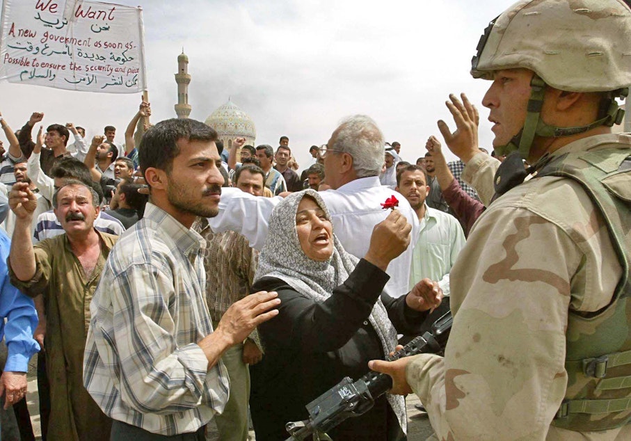 caption: An Iraqi woman offers a flower to an American Army soldier in the center of Baghdad, as hundreds of Iraqi demonstrate demanding peace and security, Saturday, April 12, 2003.