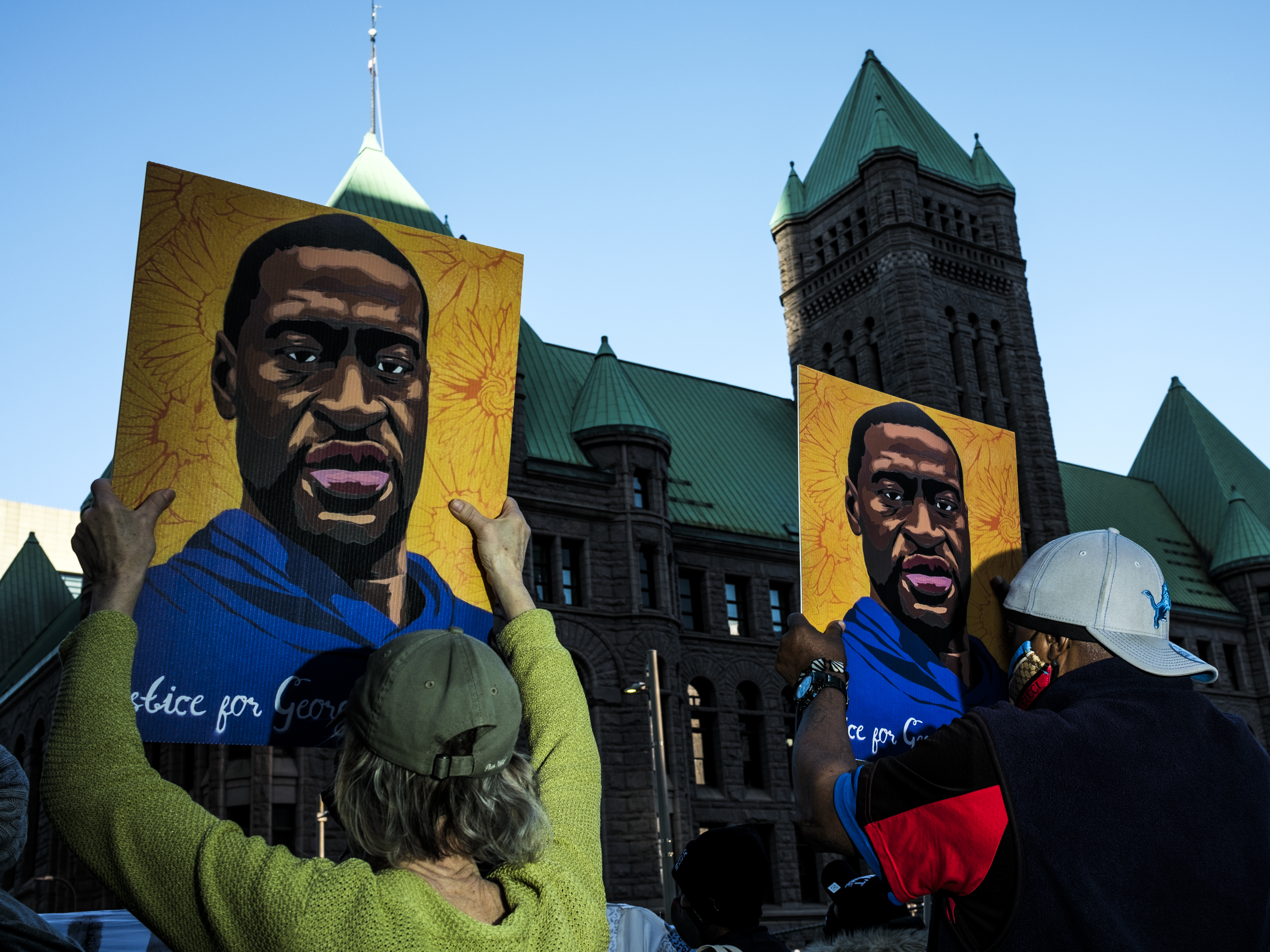 caption: People gather during a demonstration outside the Hennepin County Government Center in Minneapolis on Monday as opening statements were given in the trial of former Minneapolis police officer Derek Chauvin, charged in the killing of George Floyd.