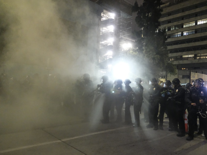 caption: Police officers fire rubber bullets May 29 during a Los Angeles protest over the death of George Floyd.