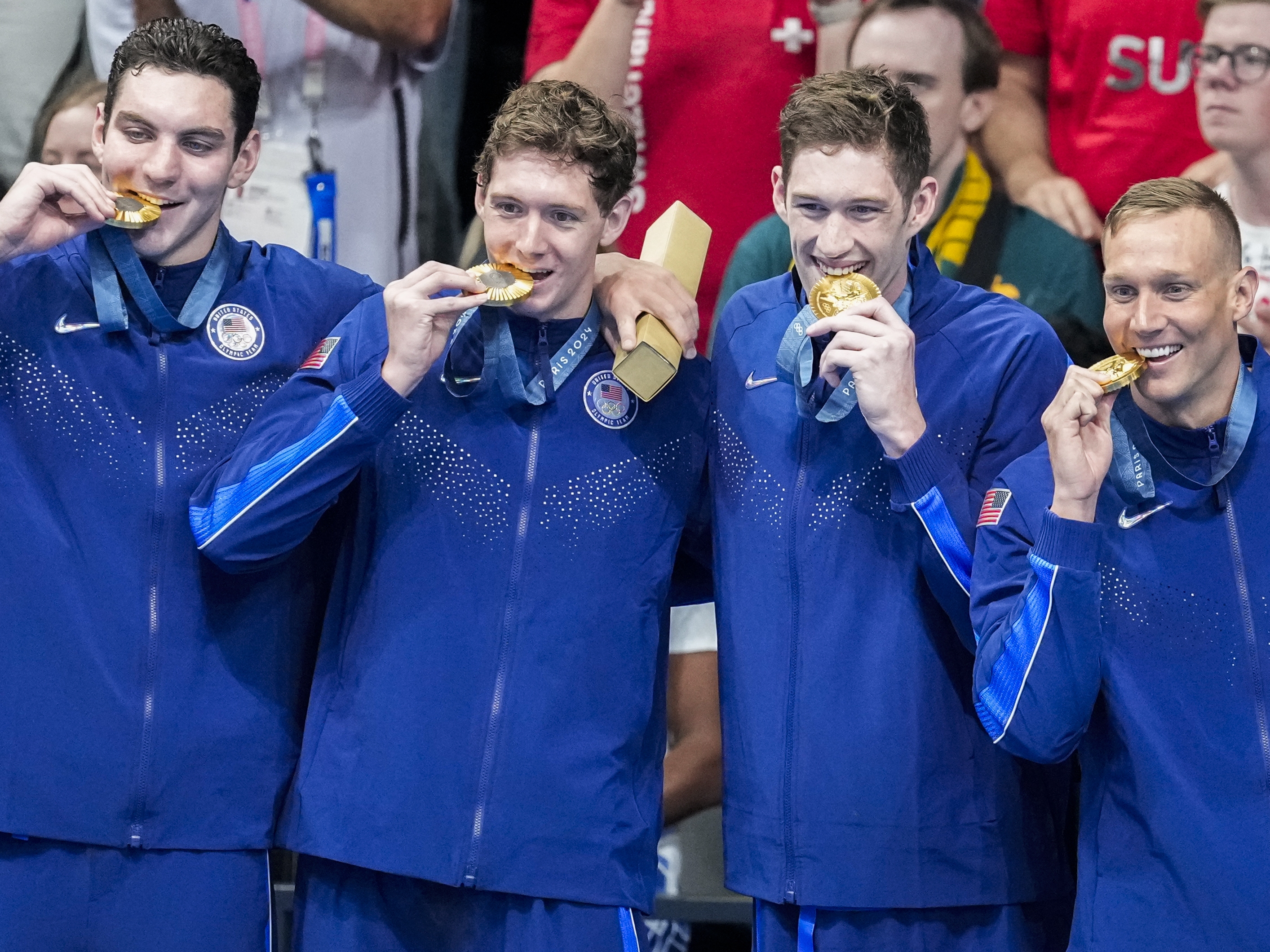 caption: Team USA's men's swimming team stands on the podium after winning gold in the men's 400-meter freestyle relay final at the Paris Olympics on Saturday.