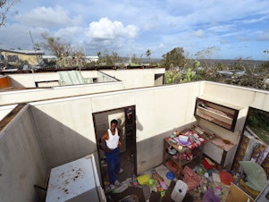 caption: Uwen Garae surveys his damaged house in Port Vila, Vanuatu in the aftermath of Cyclone Pam in 2015. The country has been hit with two category 5 storms in the last 7 years.