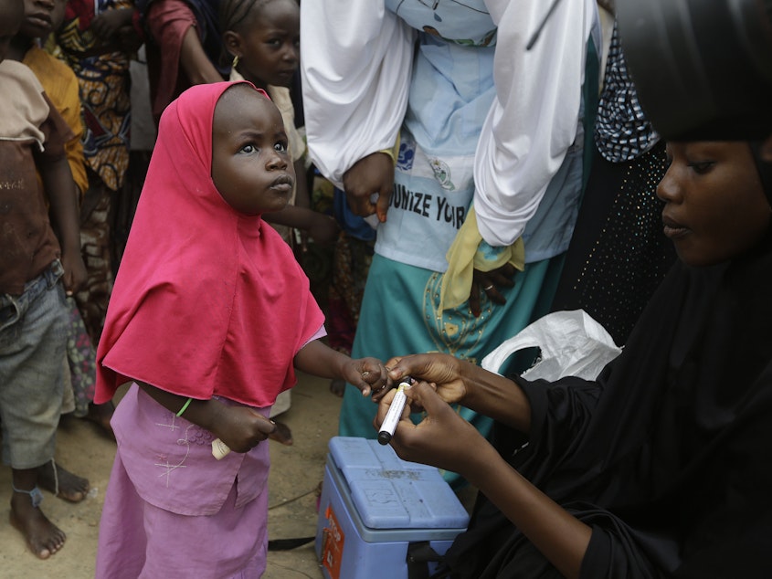 caption: Photo taken Sun., Aug. 28, 2016. A health official inks a child finger to indicate she has been administered with a polio vaccine at a camp of people displaced by Islamist extremist in Maiduguri, Nigeria.