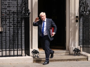 caption: Boris Johnson leaves 10 Downing St. to face questions in the House of Commons in London on Wednesday.