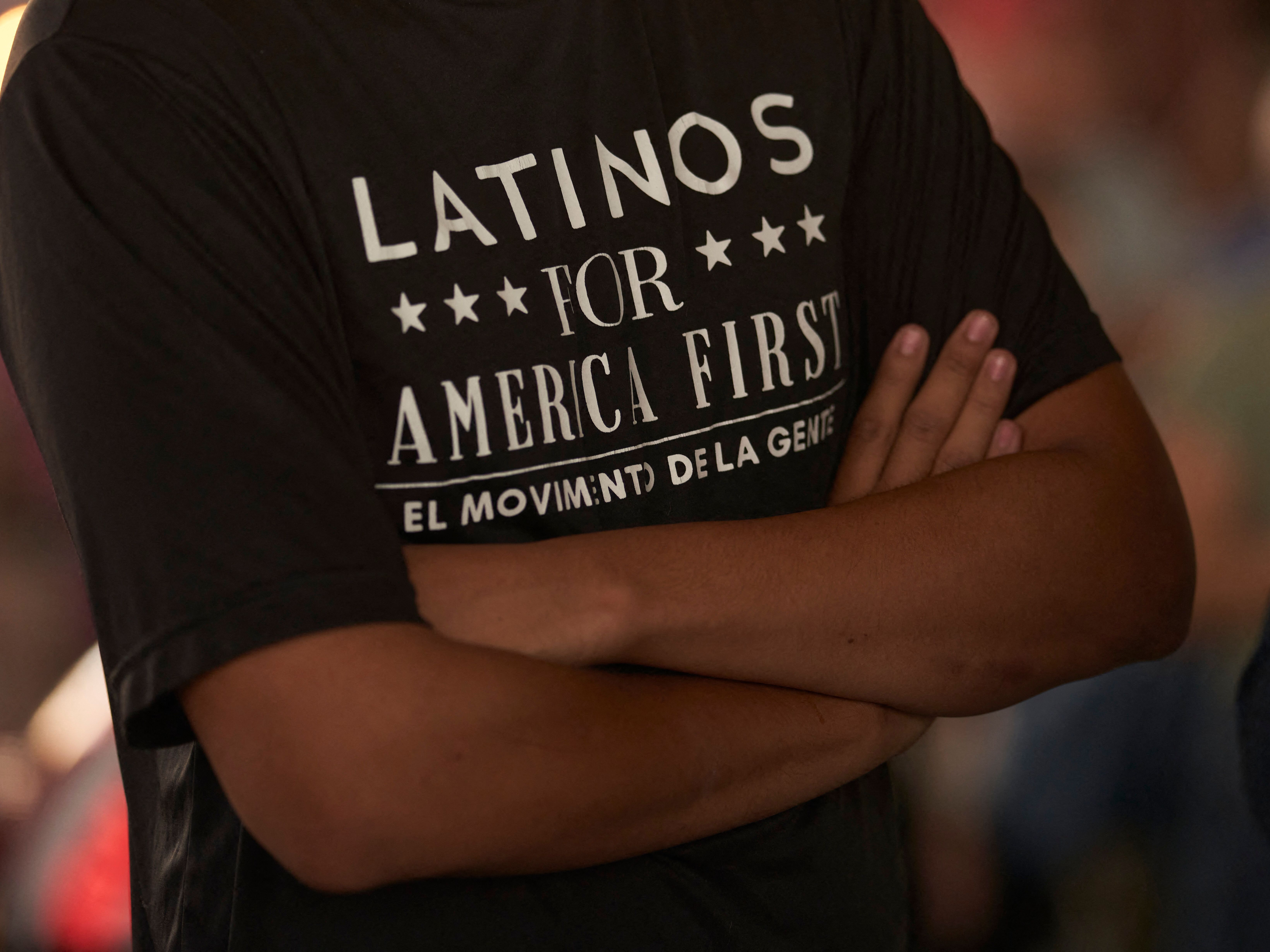 caption: A man wearing a "Latinos for America" T-shirt attends a campaign event for Republican congressional candidates at University Drafthouse in McAllen, Texas, in 2022.