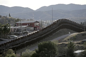 caption: The president declared a national emergency in February to access federal money to build a wall similar to this razor-wire-covered border wall separating Nogalas, Mexico (left), and Nogales, Ariz. Congress did not approve the full amount he asked for last year to follow through on a key campaign pledge.
