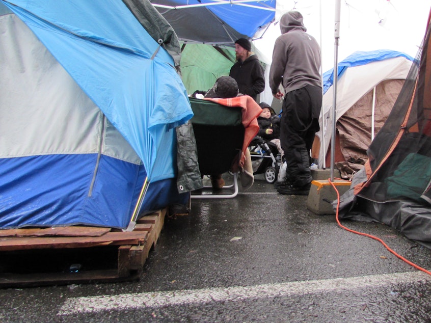 caption: Billy Plur (rear) and other residents of a homeless camp in Seattle's University District.