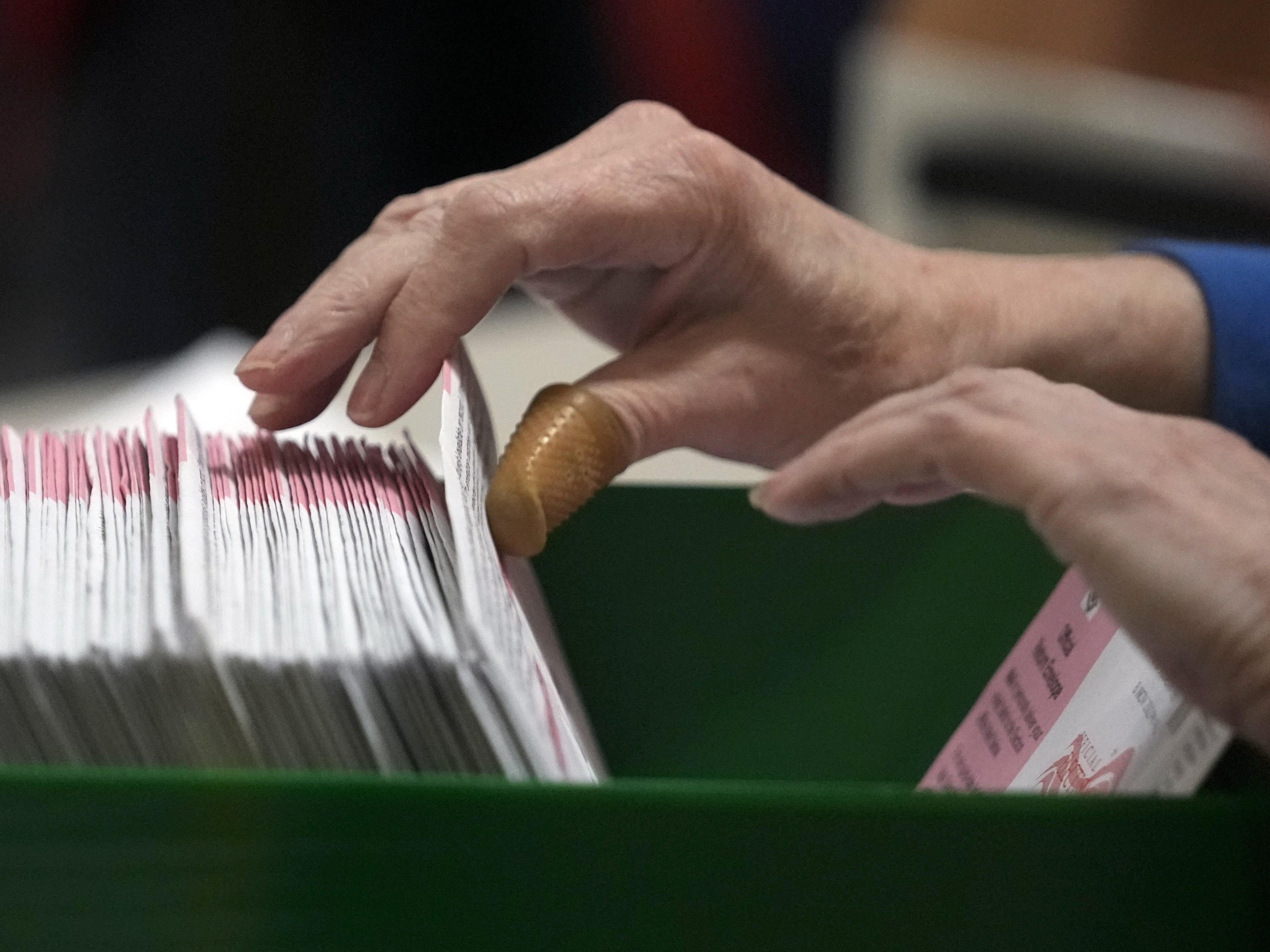 caption: An election worker processes ballots at the Clark County Election Department in Las Vegas on Nov. 10, 2022.